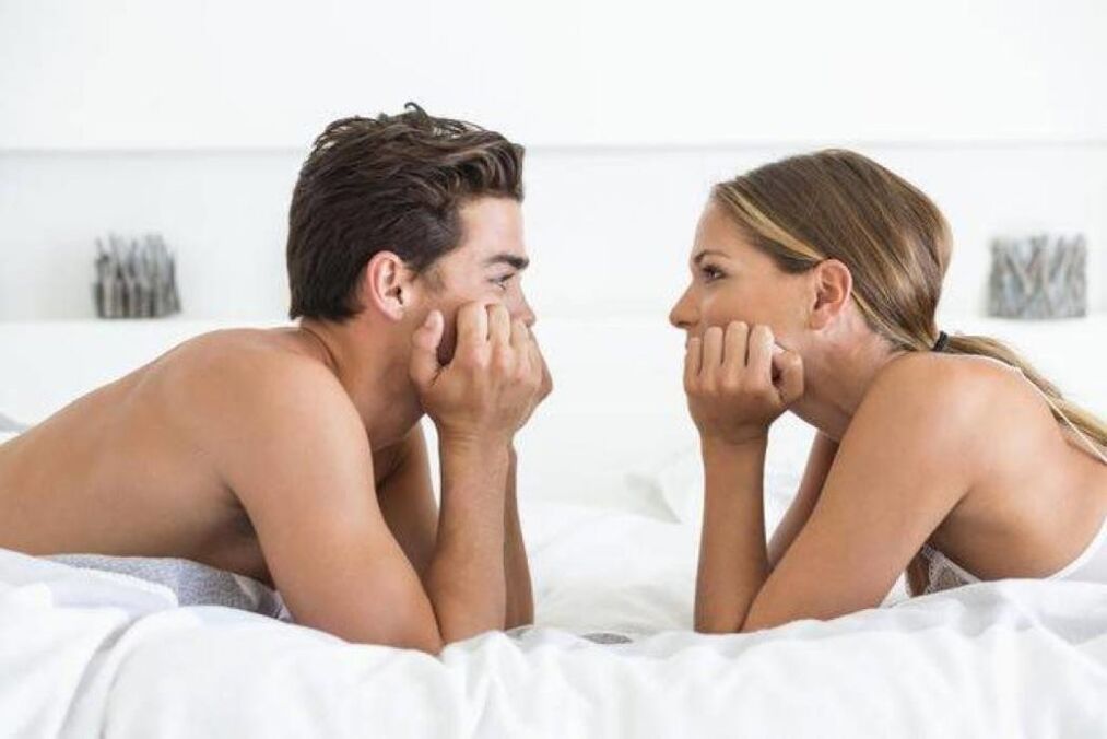 uma mulher na cama com um homem com um pênis dilatado